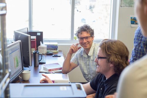 Two men smiling at a computer